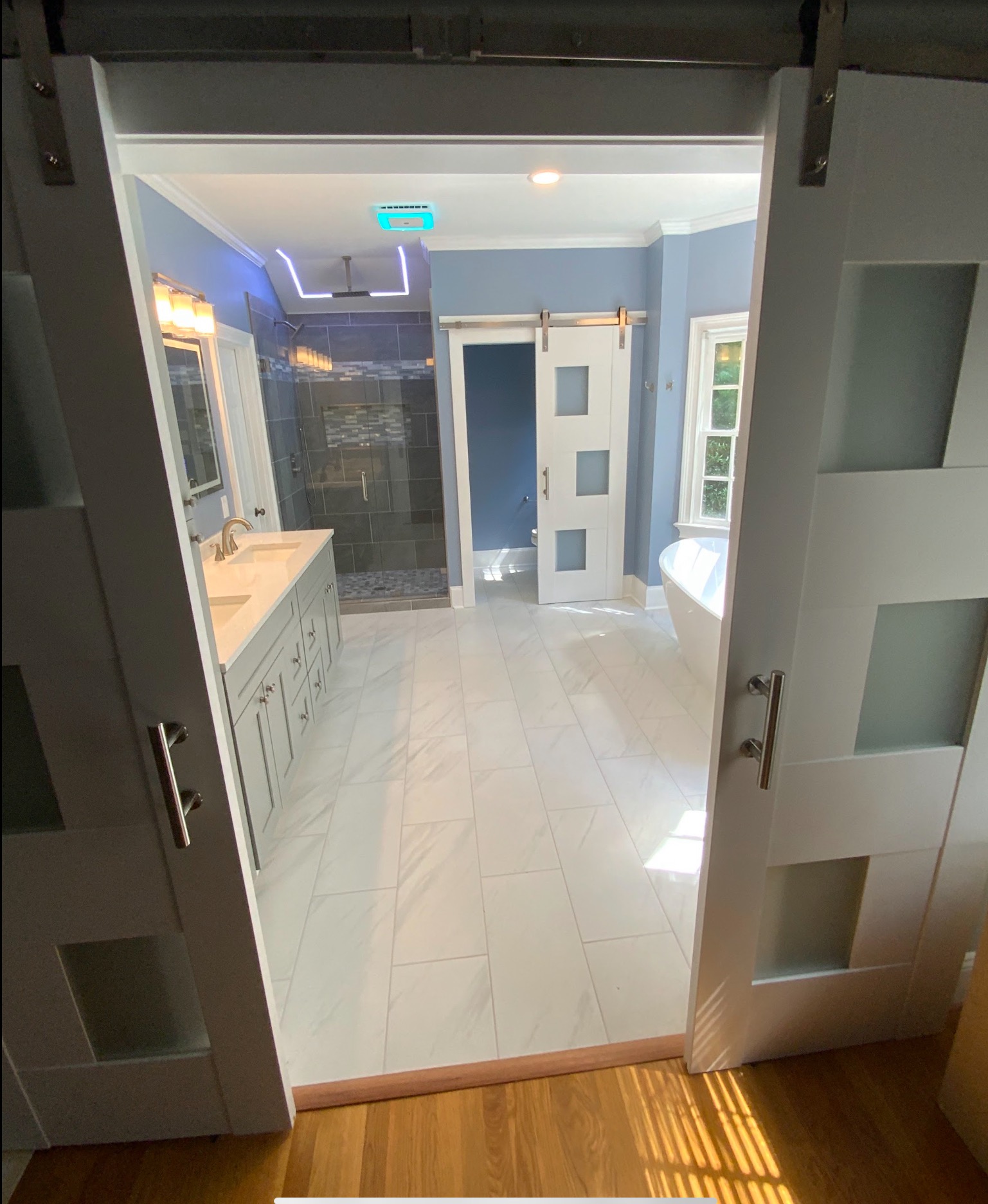 Completed bathroom with a white barn door
